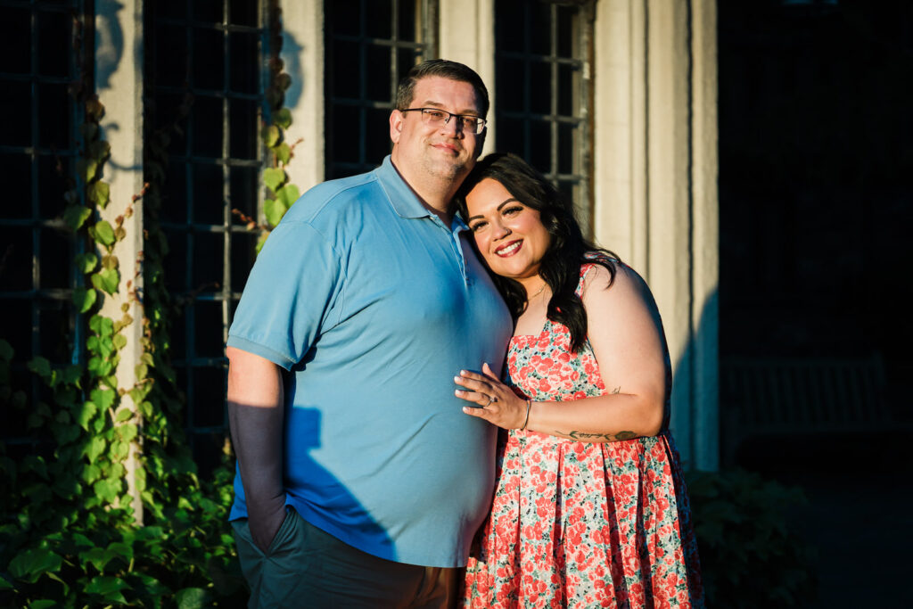 Engaged couple posing near manor windows at Skylands Manor in Ringwood NJ