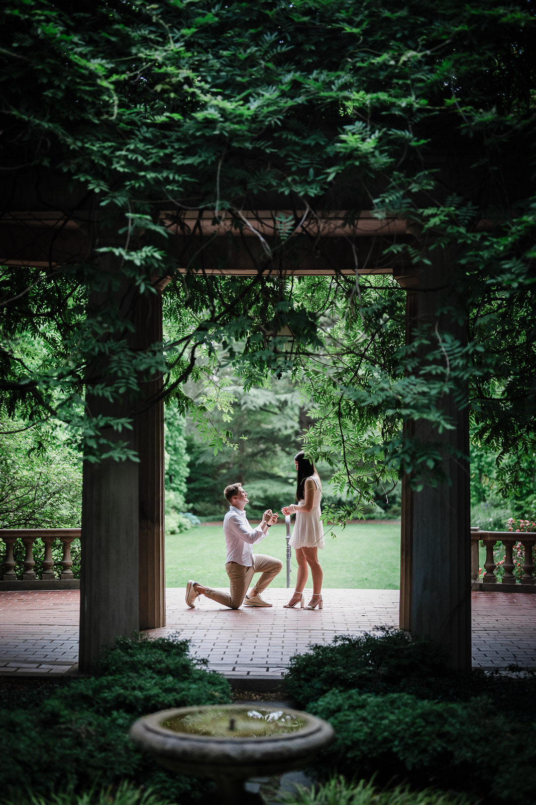 Surprise proposal moment as a man kneels under the Van Vleck House colonnade in Montclair NJ