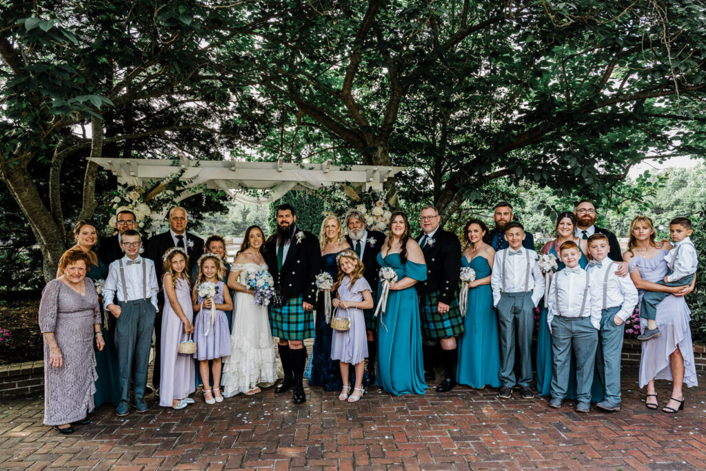 Bride and groom posing with extended family at the Smithville Inn in Galloway NJ
