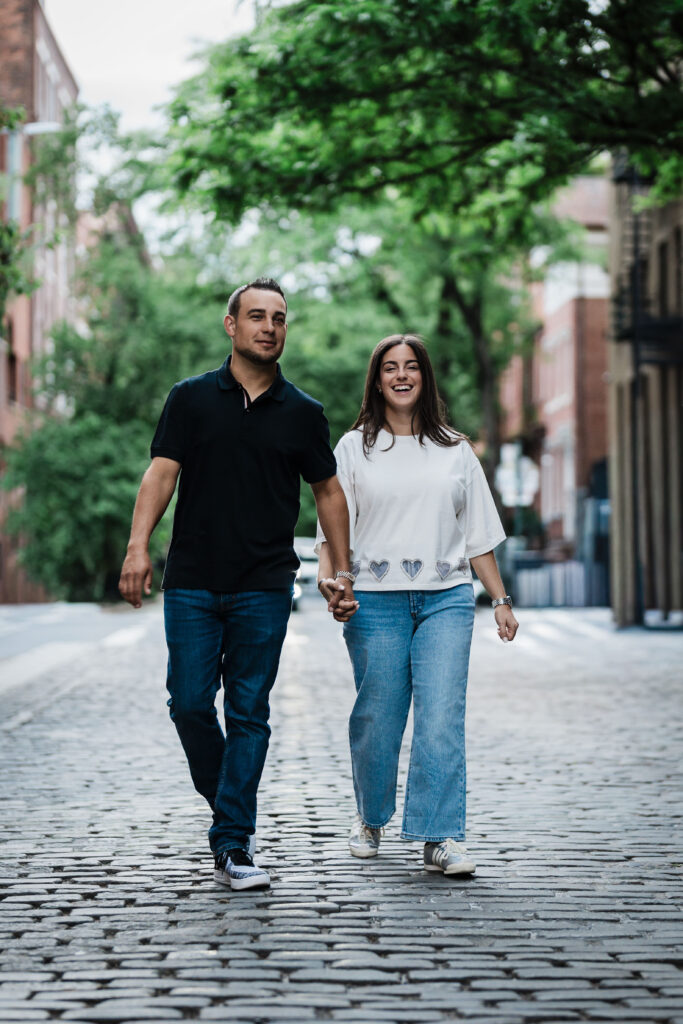 Engaged couple walking a West Village street after dinner during their NYC date-night engagement session