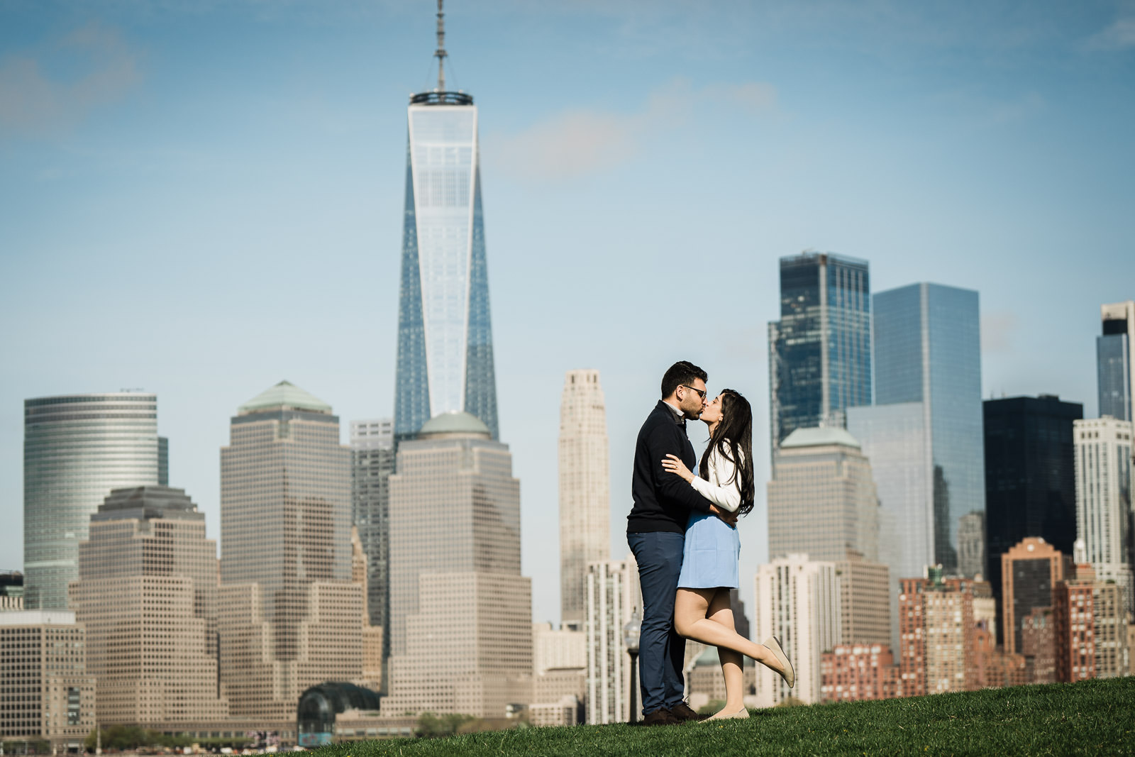 Couple kissing by a New Jersey waterfront with Manhattan skyline behind them