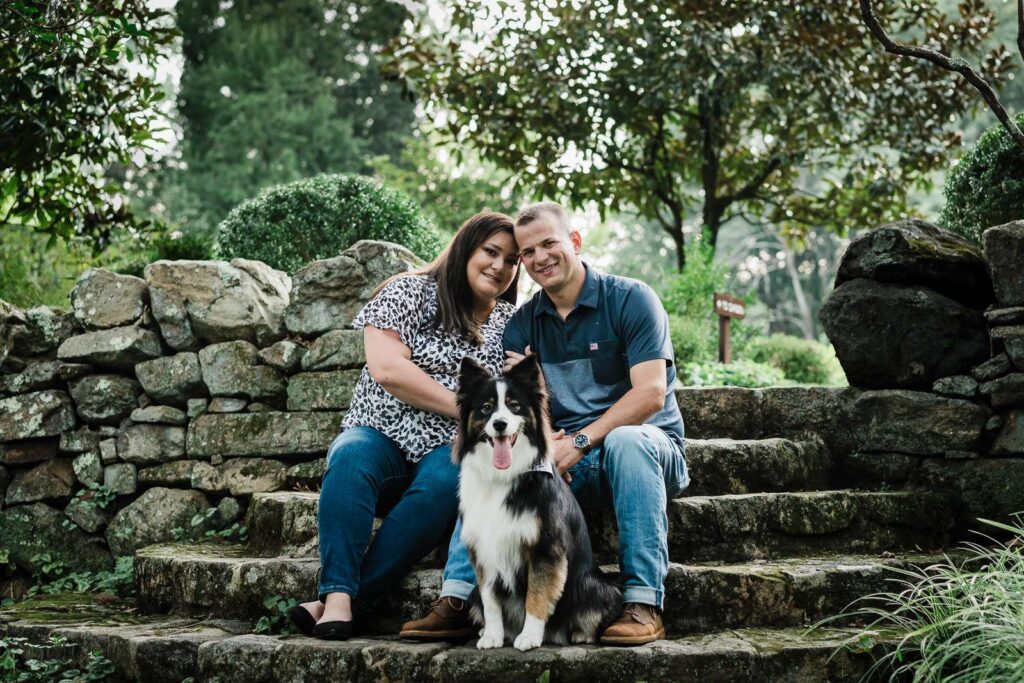 Couple sitting with their dog on garden steps during a Crossed Keys Estate engagement session