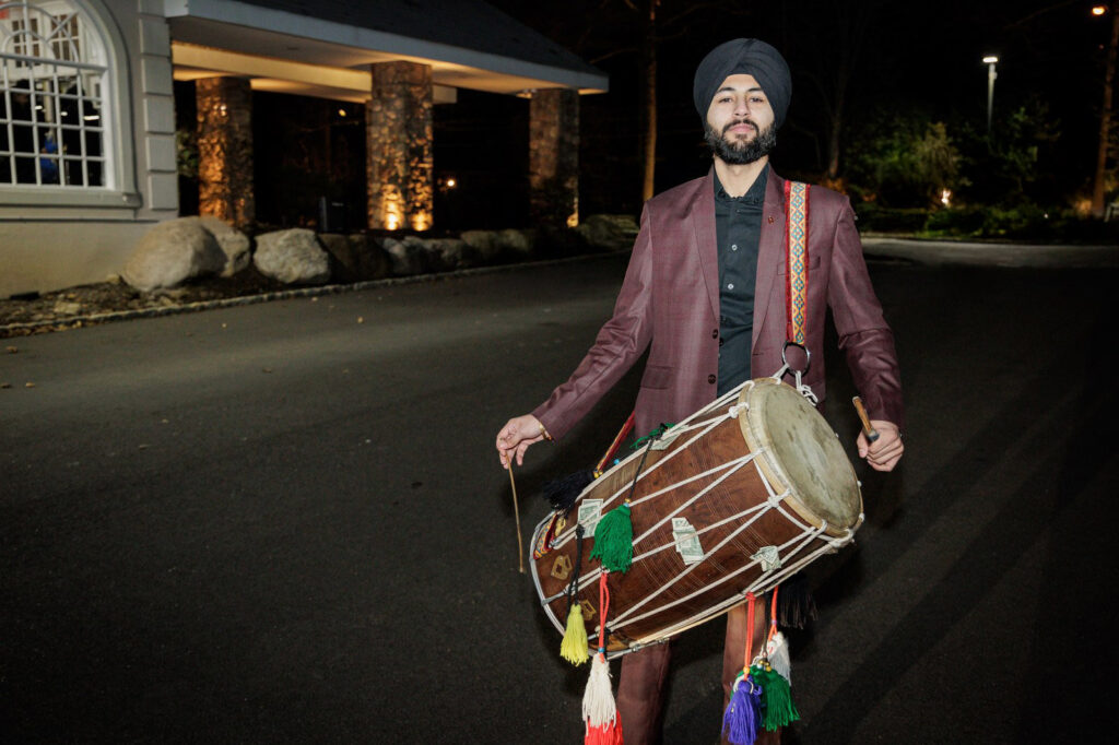 Dhol drummer leads the baraat procession outside a New Jersey Indian wedding venue