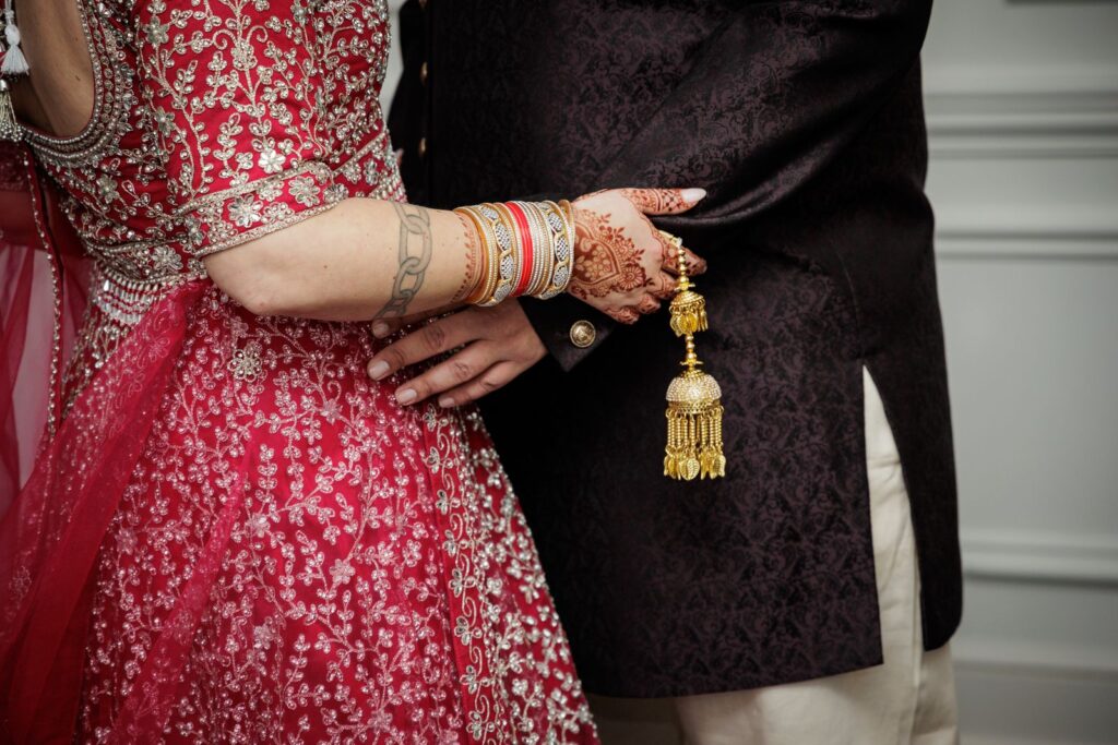 Bride and groom hold hands wearing kalira bangles during their New Jersey wedding ceremony