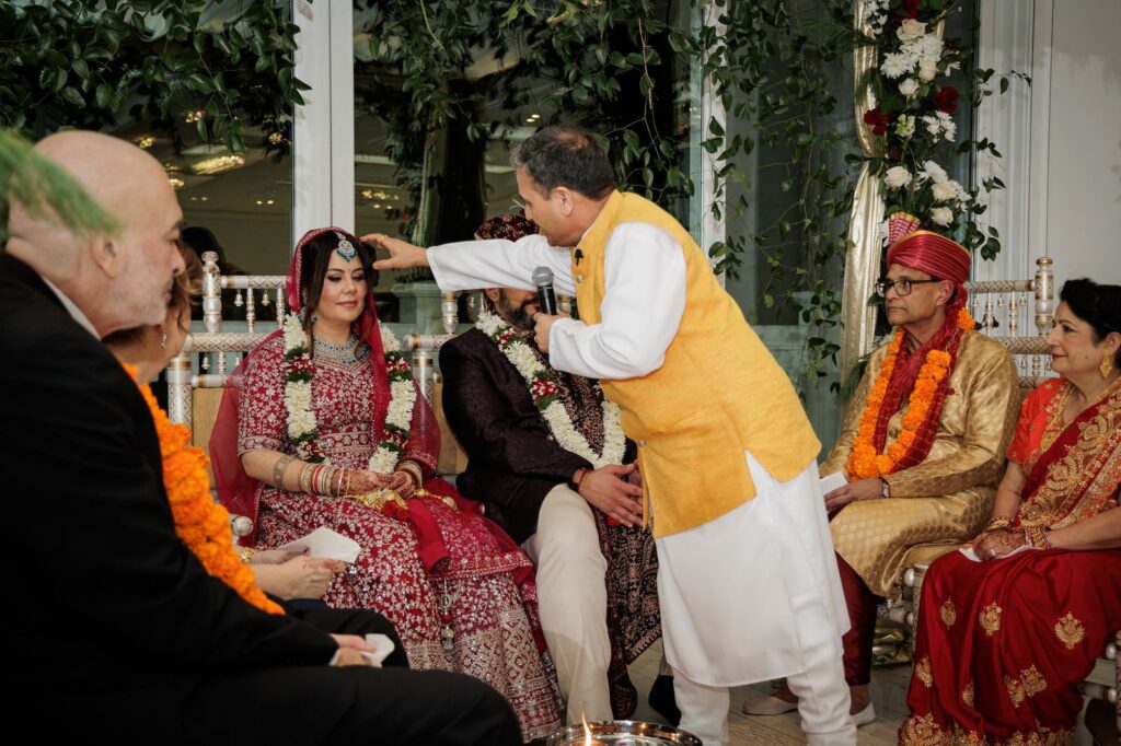 Officiant applies a blessing to the bride during a mandap ceremony in New Jersey
