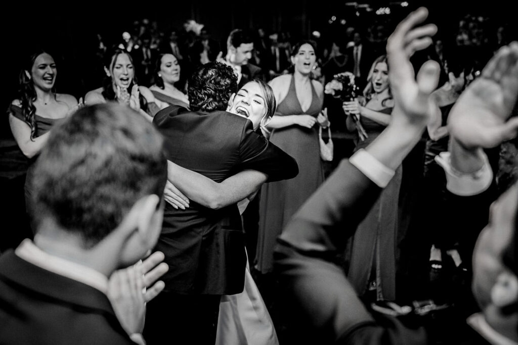 Wedding guests filling the dance floor during an evening reception celebration.
