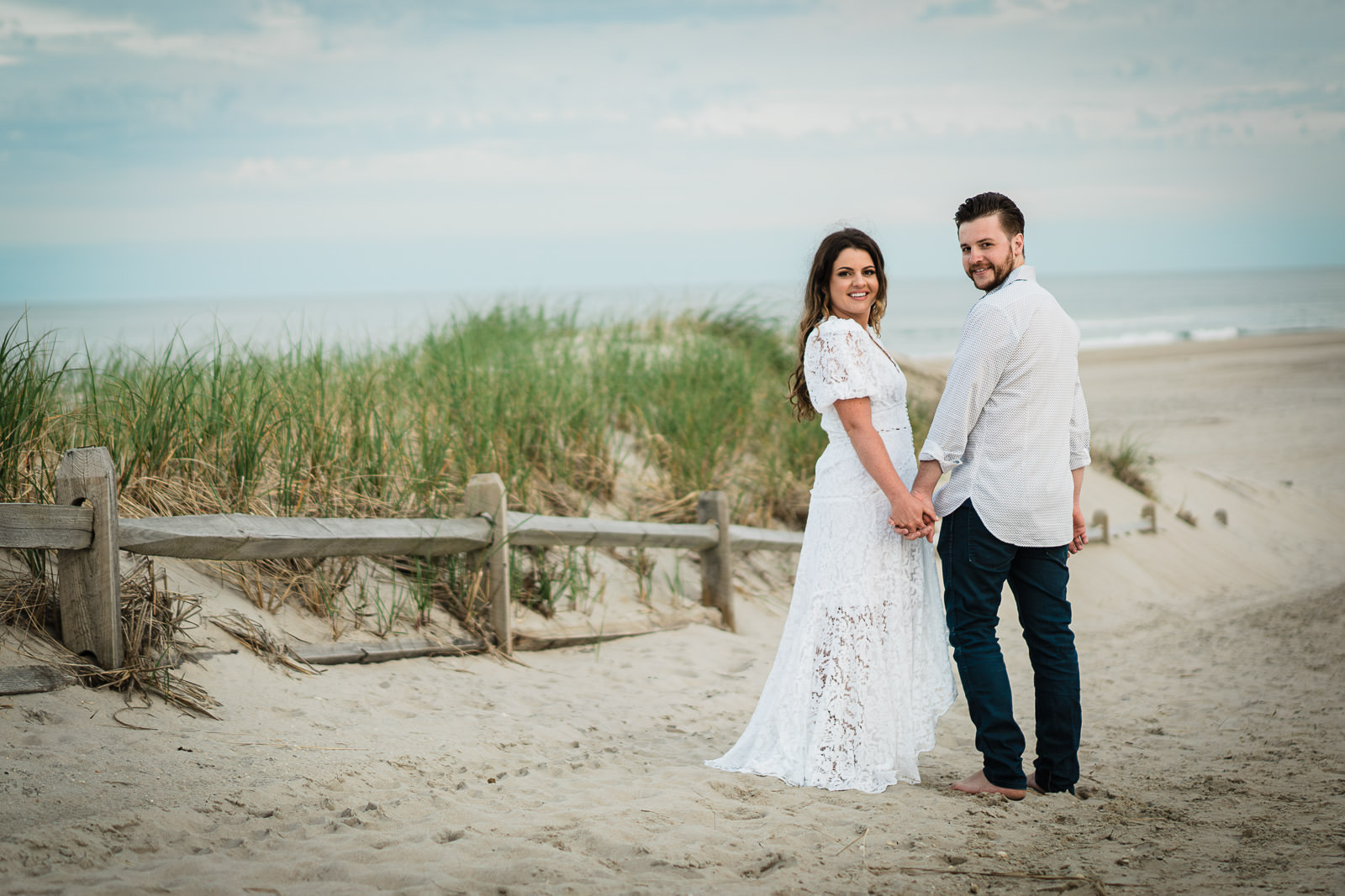 Missy and Alex posing for beach engagement photos in New Jersey