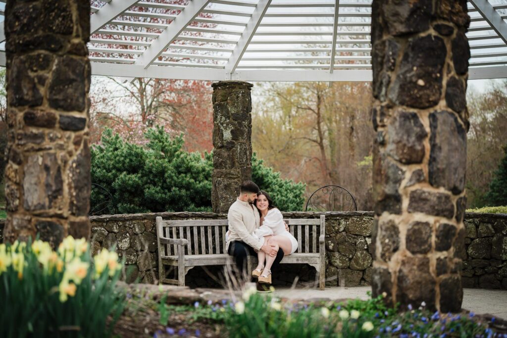 Couple sitting beneath the stone pergola at Deep Cut Gardens in Middletown New Jersey