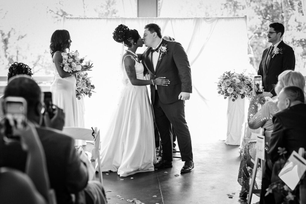 First kiss during an intimate wedding ceremony at Abington Art Center