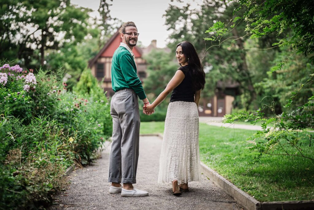 Philip and Lexi holding hands on a garden path at Van Vleck House Montclair NJ