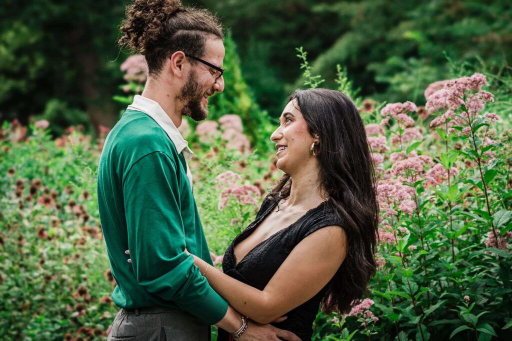 Philip and Lexi facing each other among tall summer blooms at Van Vleck Gardens Montclair