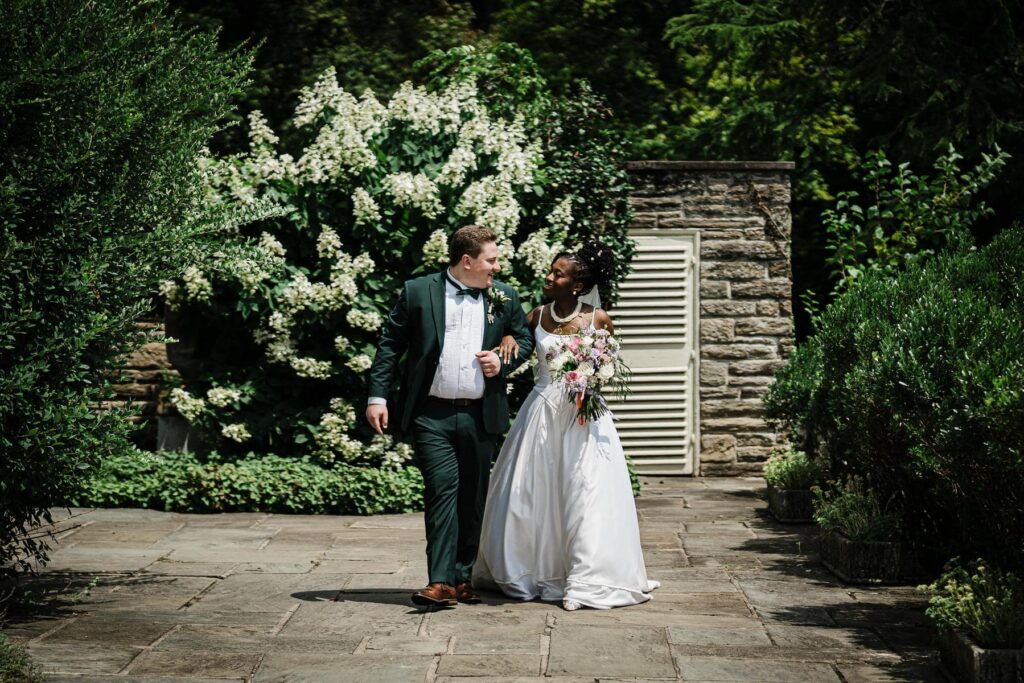 Bride and groom beside a floral arch during their Jenkintown PA wedding