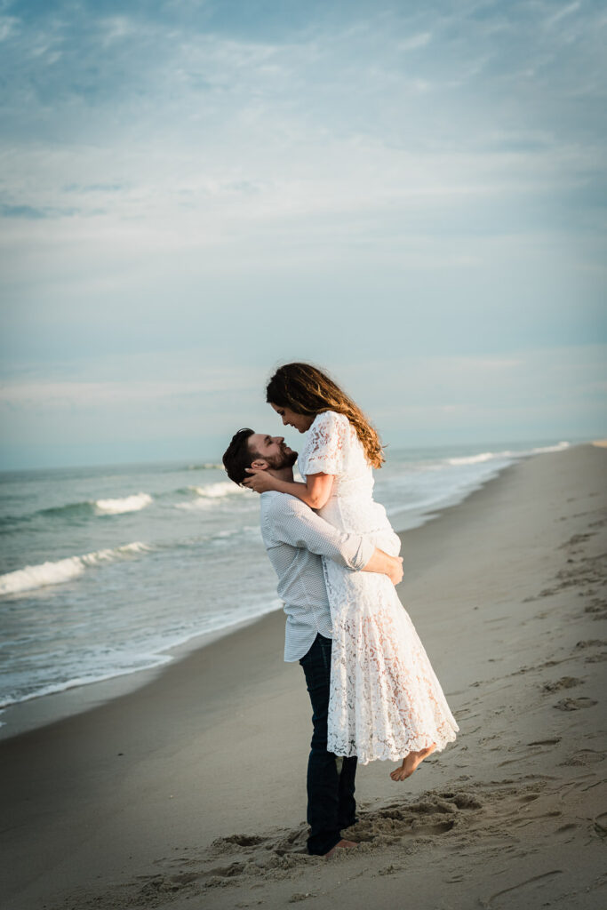 Couple mid lift at the shoreline during an NJ beach engagement session