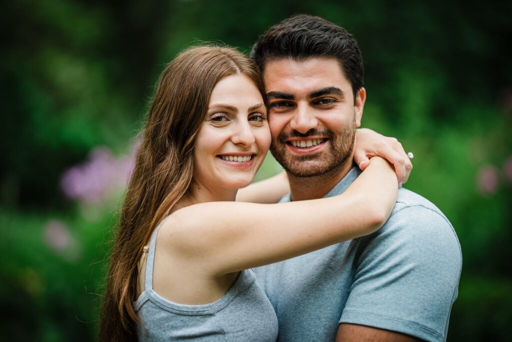 Close portrait of a newly engaged couple embracing in the gardens at Van Vleck