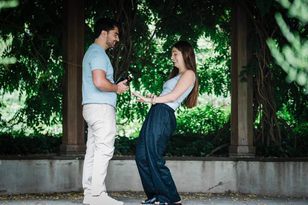 Newly engaged woman extending her hand for the ring at Van Vleck Gardens Montclair