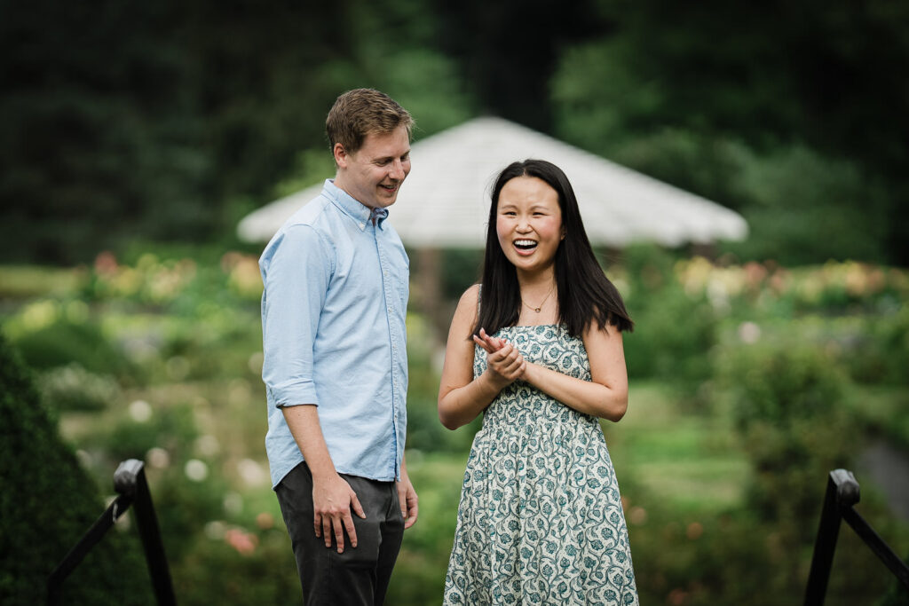 Emily laughing with her hands clasped just after the proposal at Deep Cut Gardens