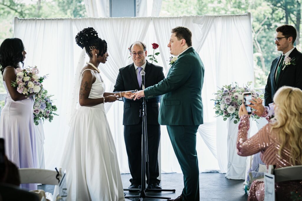 Bride and groom exchanging vows and rings during their pavilion wedding ceremony
