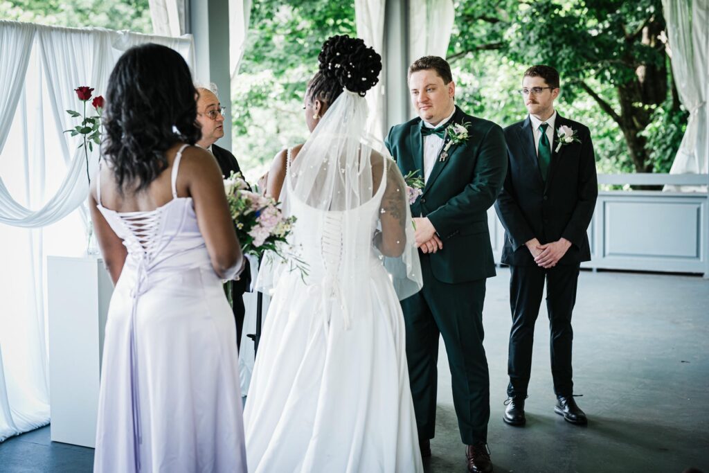 Bride and groom exchanging vows and rings during their pavilion wedding ceremony