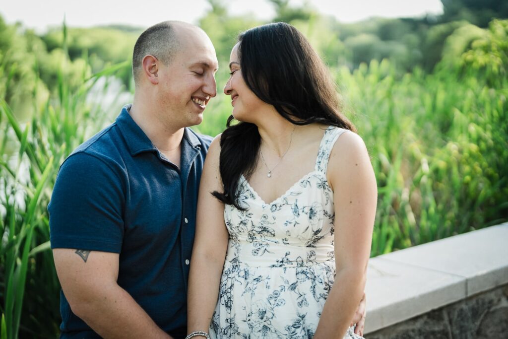 Engaged couple laughing face to face beside the reeds at Burnham Park in Morristown