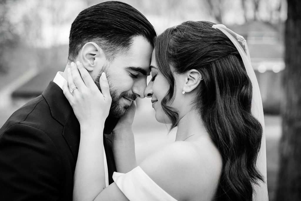 Bride holding her groom's face as they touch foreheads at Waterloo Village in New Jersey
