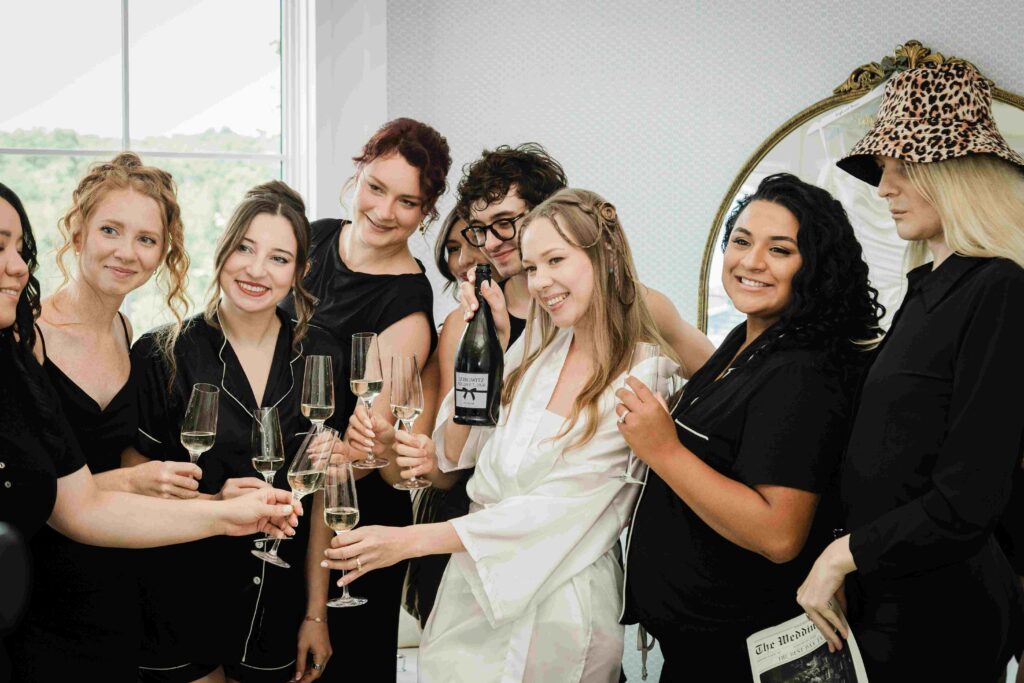  Bride and her wedding party toasting with champagne at The Mill Lakeside Manor