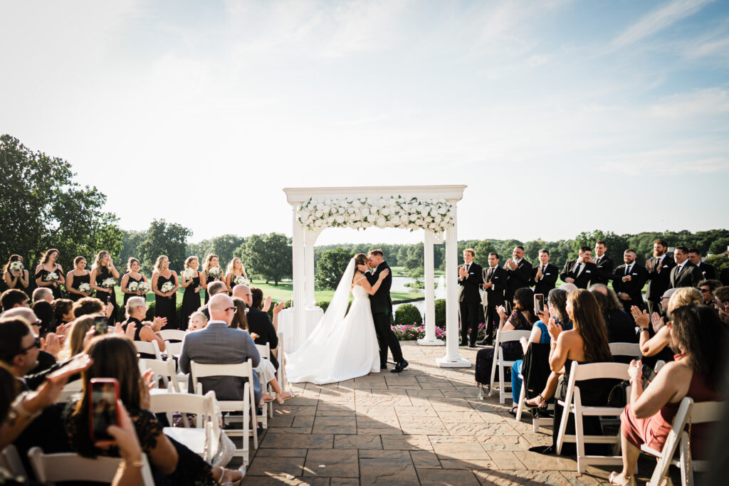 Ilysse and James kissing at their ceremony overlooking the lake at Brooklake Country Club