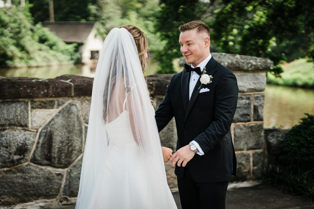 Ilysse and James together beside the stone wall at Brooklake Country Club