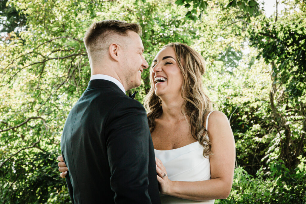Ilysse and James laughing together during portraits at Brooklake Country Club