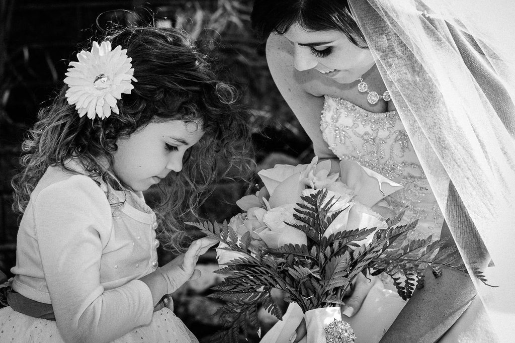 Flower girl studying the bride's bouquet during a Buttonwood Manor wedding ceremony in New Jersey