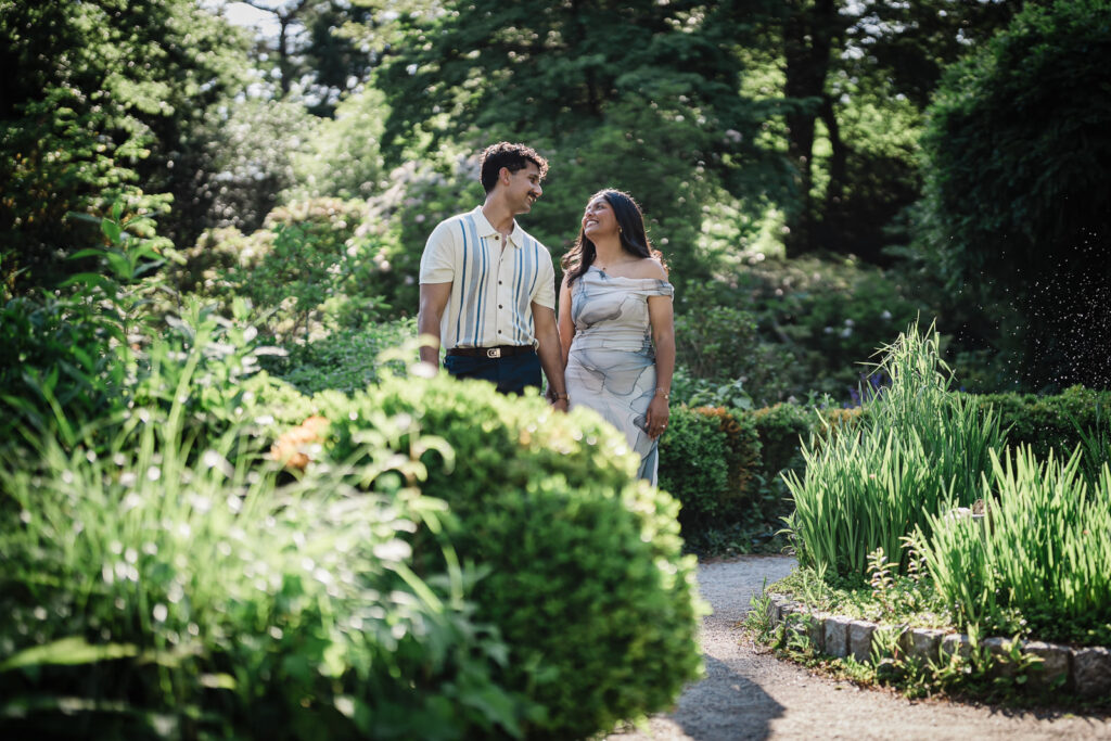 Couple surrounded by garden plantings during an engagement session at Deep Cut Gardens