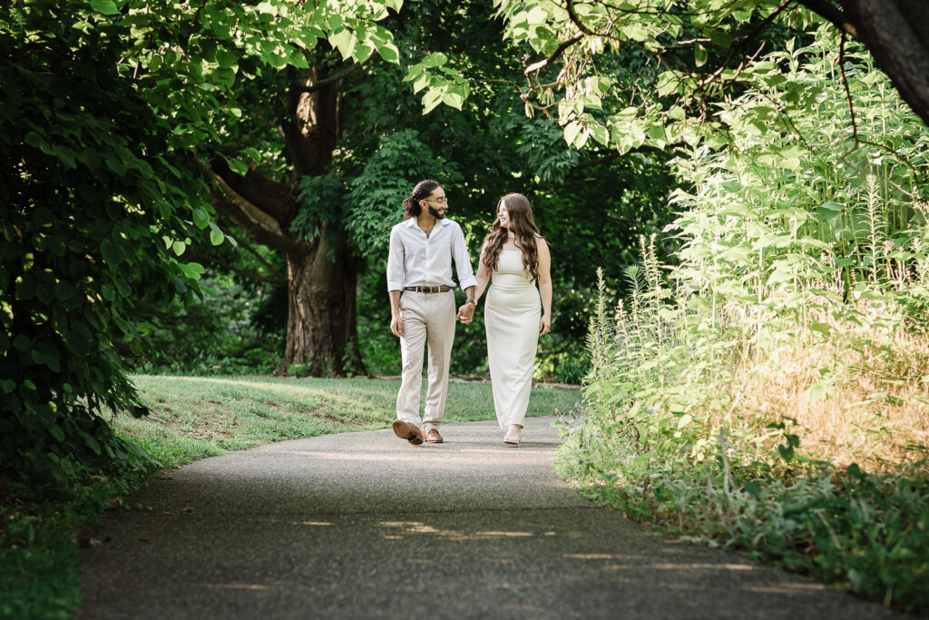Engaged couple walking a shaded garden path during a Deep Cut Gardens engagement session