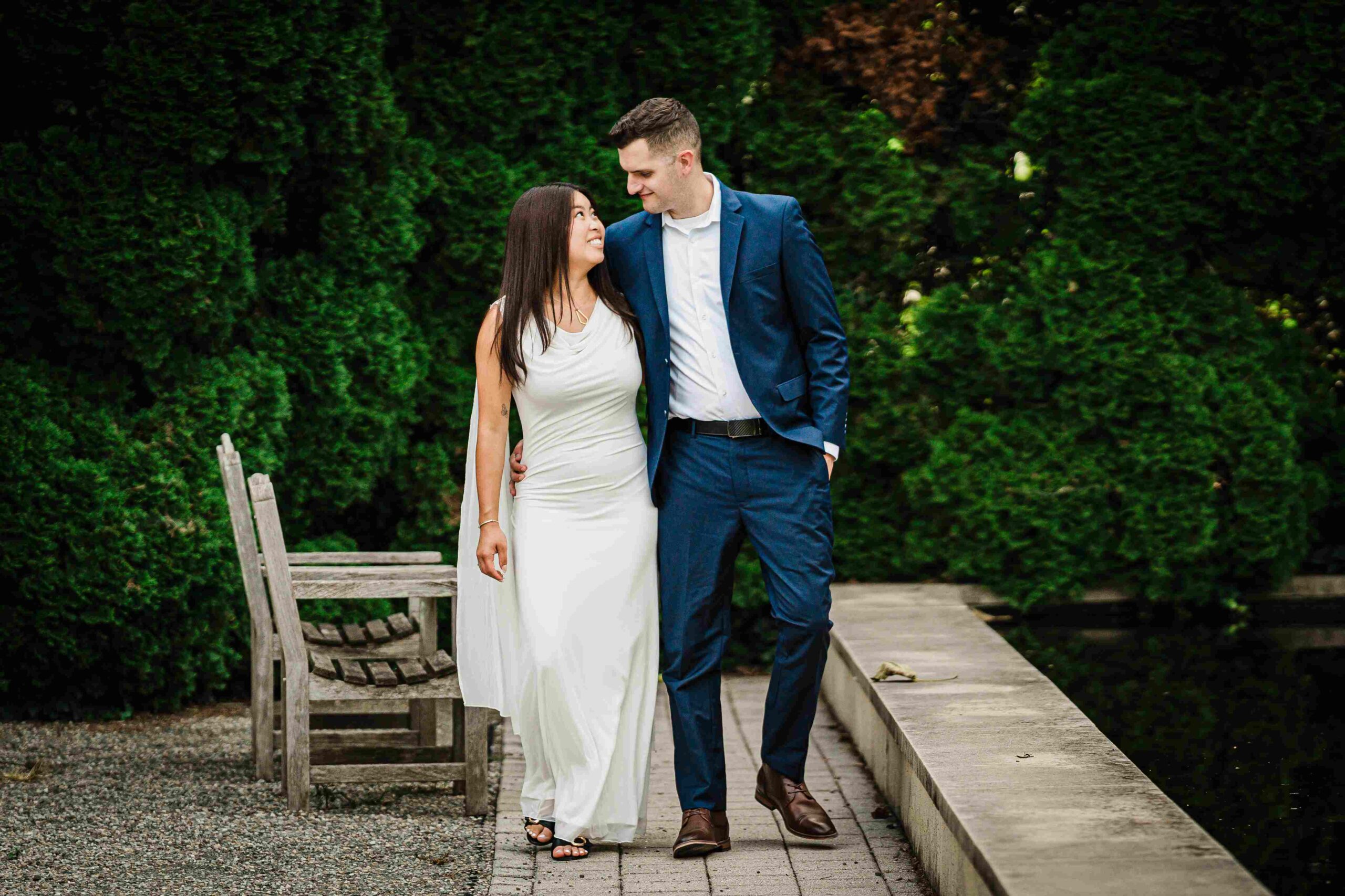Couple looking at each other on a garden pond walkway at Grounds For Sculpture in New Jersey