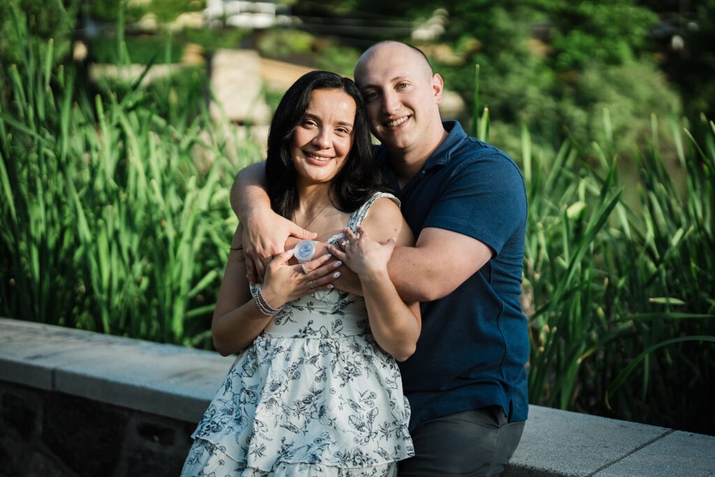 Engaged couple embracing beside the pond reeds at Burnham Park in Morristown New Jersey