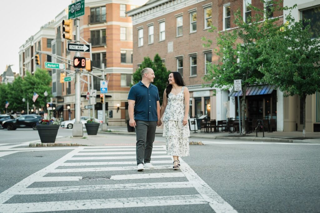 Engaged couple walking across a Market Street crosswalk in downtown Morristown New Jersey