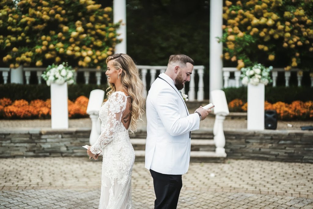 Bride and groom reading private vows back to back before a first look at The Legacy Castle