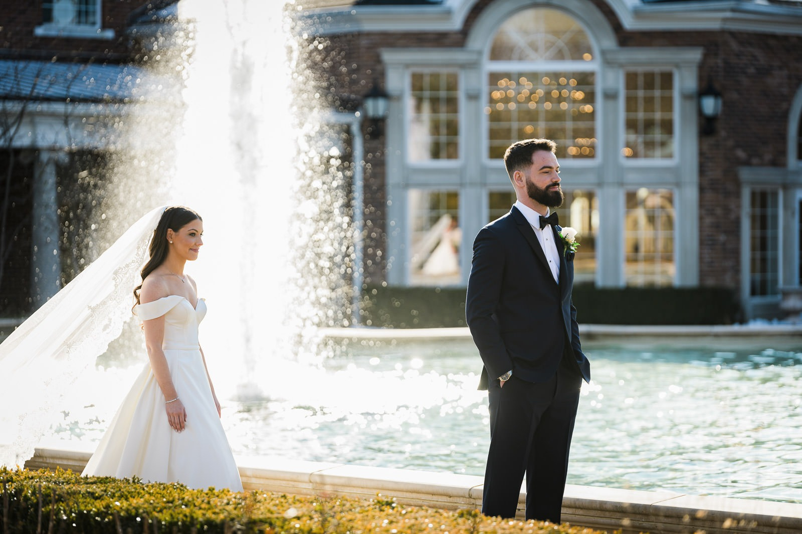 Bride approaching groom for first look beside the fountain at The Rockleigh