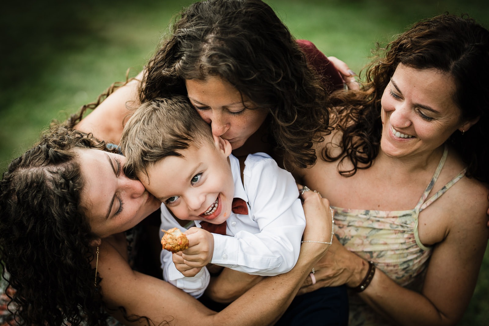 Smiling young boy being hugged by guests at a New Jersey wedding