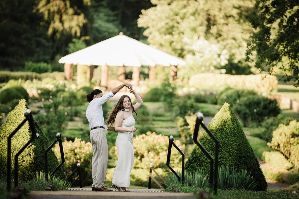 Natural save the date engagement photo of a couple dancing on garden steps in New Jersey