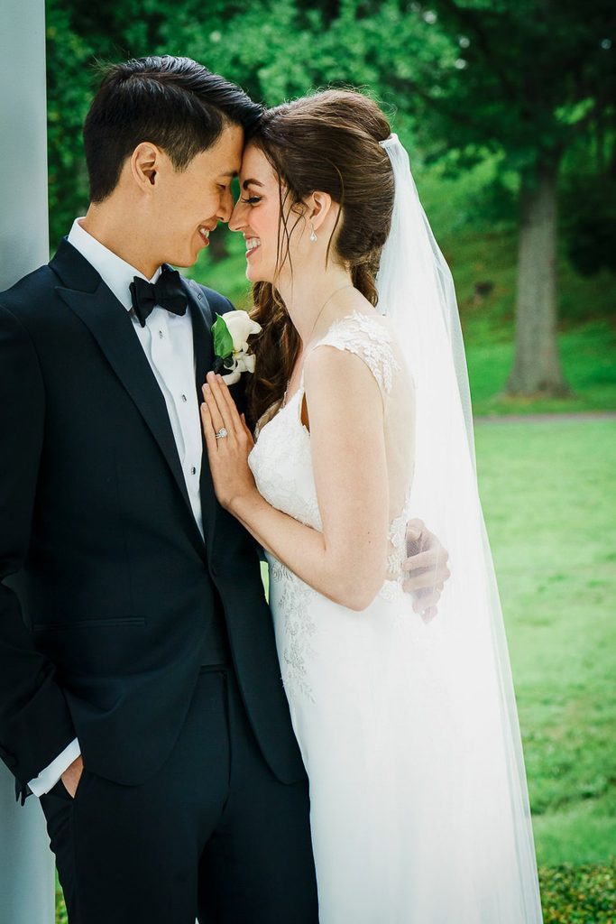 Close wedding portrait in soft overcast light beside a covered pavilion column