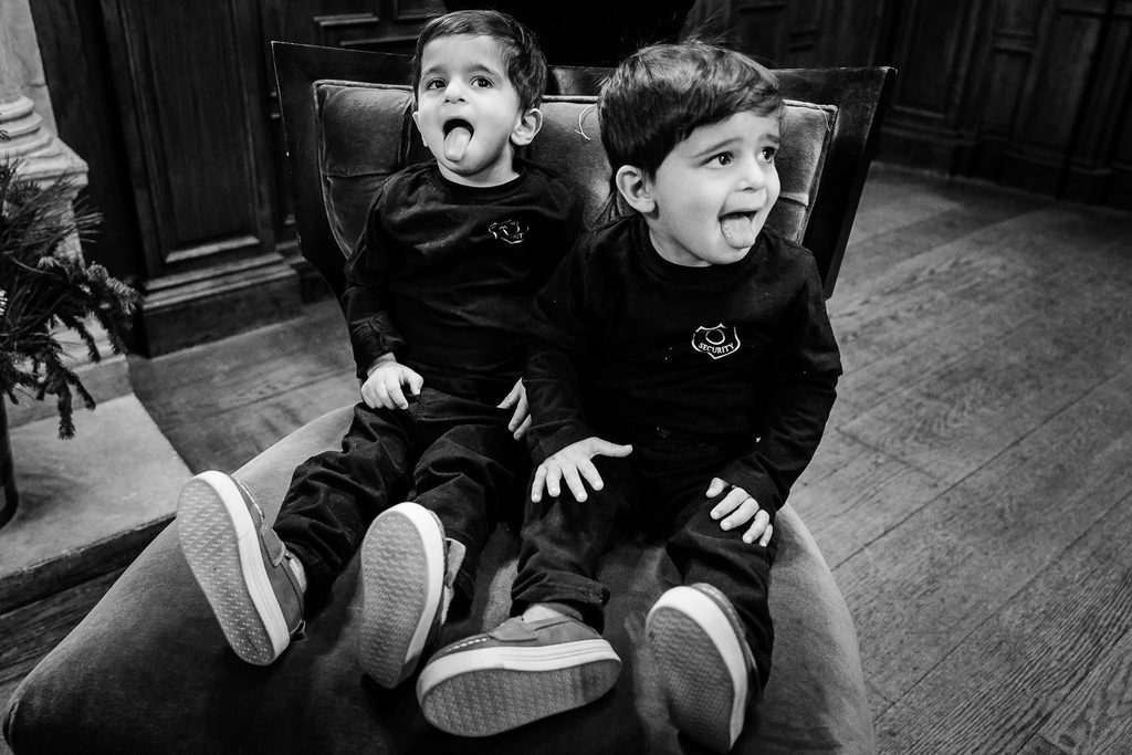 Two young boys pulling faces in an armchair at a Skylands Manor wedding in Ringwood NJ