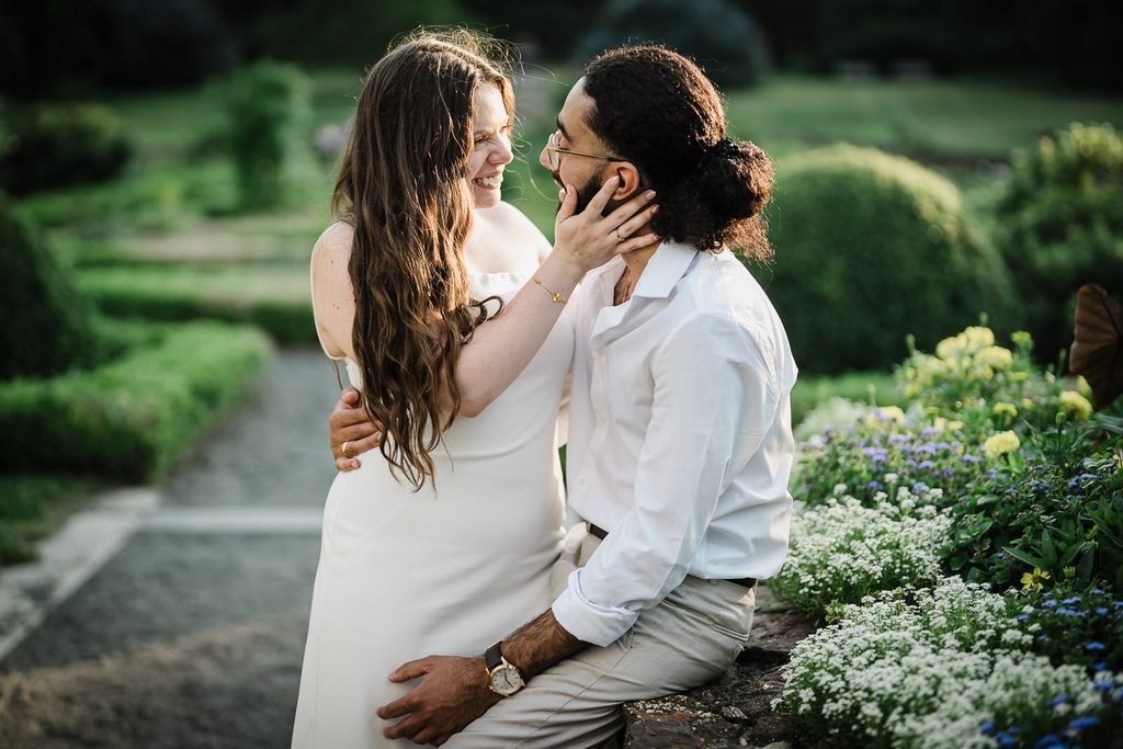 Save the date engagement photo idea of a couple sharing a tender moment by flowers