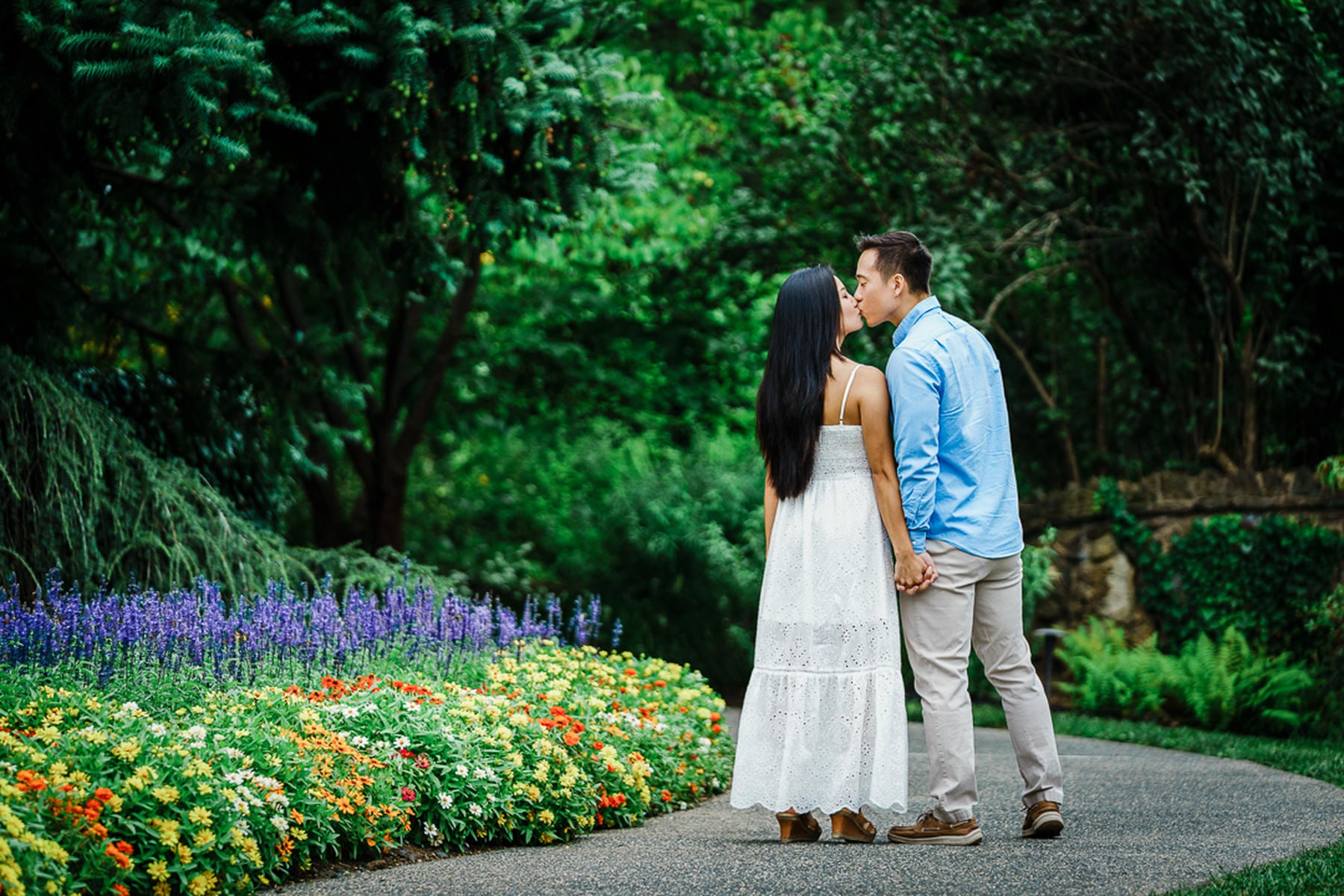 Engaged couple sitting together in summer greenery during a New Jersey session