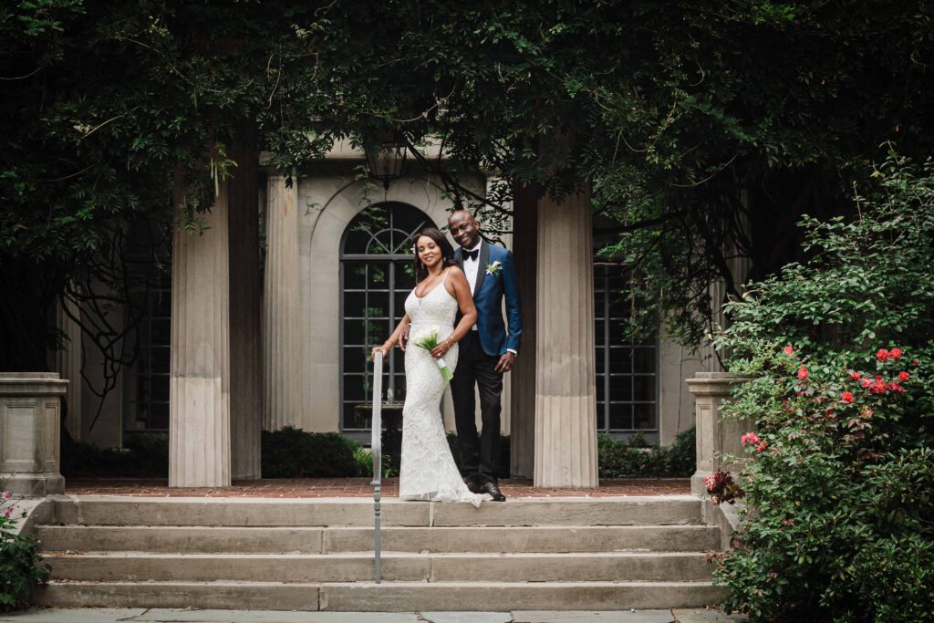 Wide wedding portrait on the columned steps at Van Vleck House and Gardens