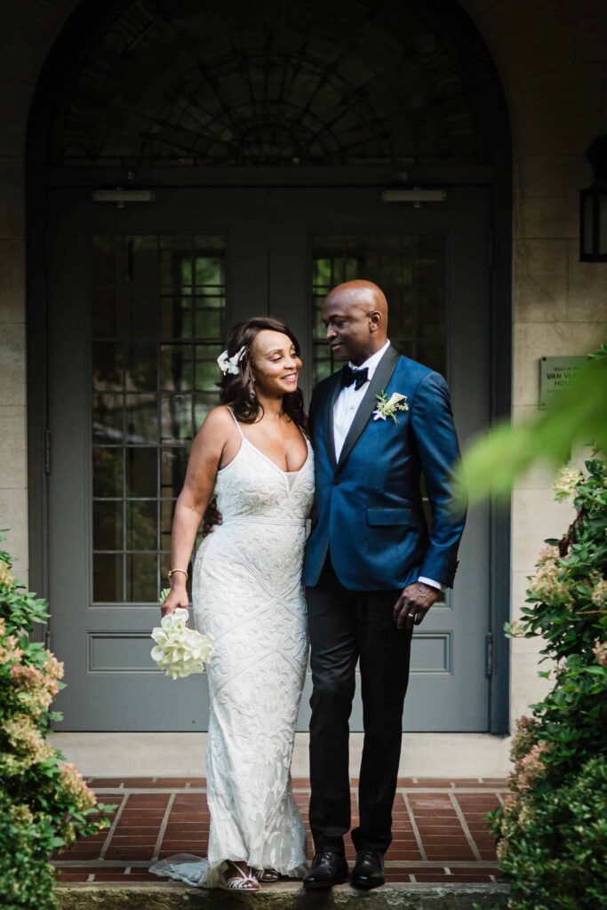 Allison and Pascal smiling under the arched doorway at Van Vleck House Gardens