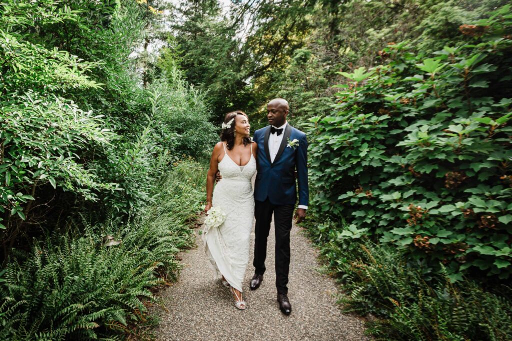 Couple walking a fern lined gravel path at Van Vleck House and Gardens