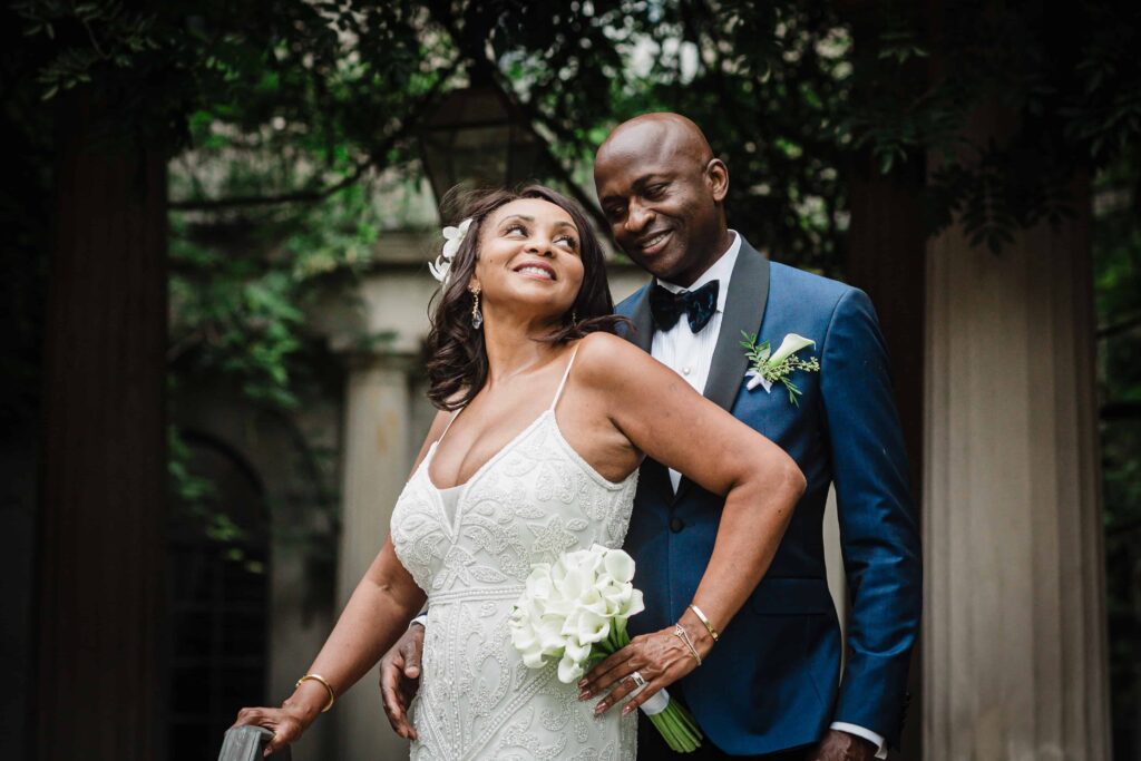 Bride laughing with her groom beside the columns at Van Vleck House Montclair