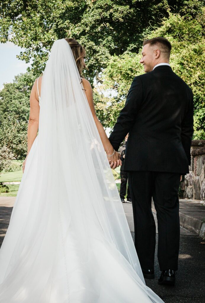 Ilysse and James walking together through the grounds at their Florham Park wedding