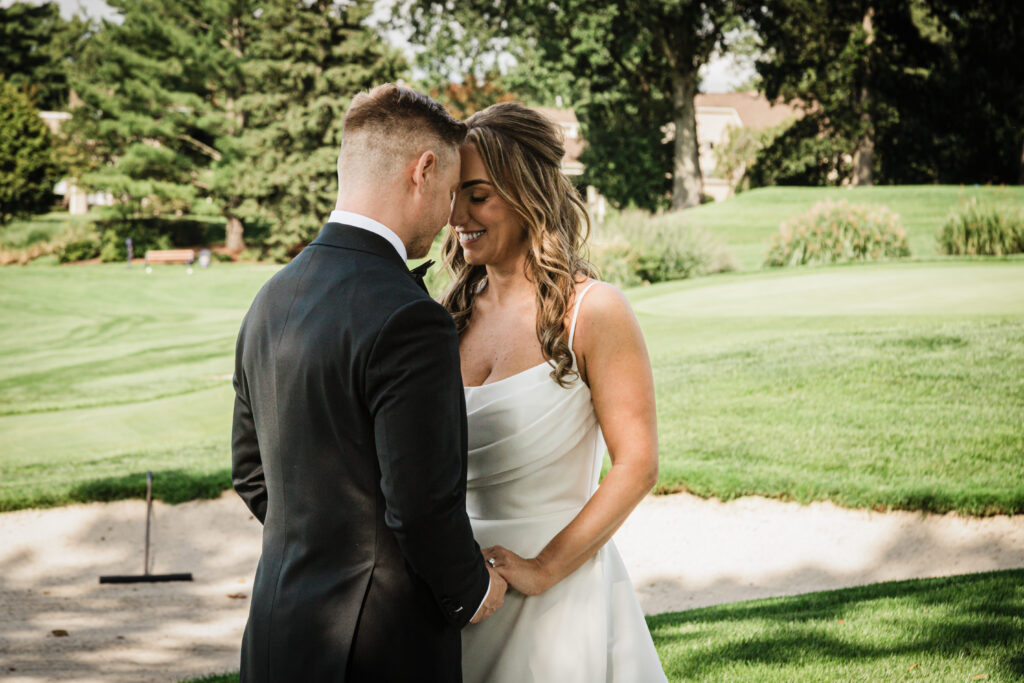 Ilysse and James close together on the course at their Brooklake Country Club wedding