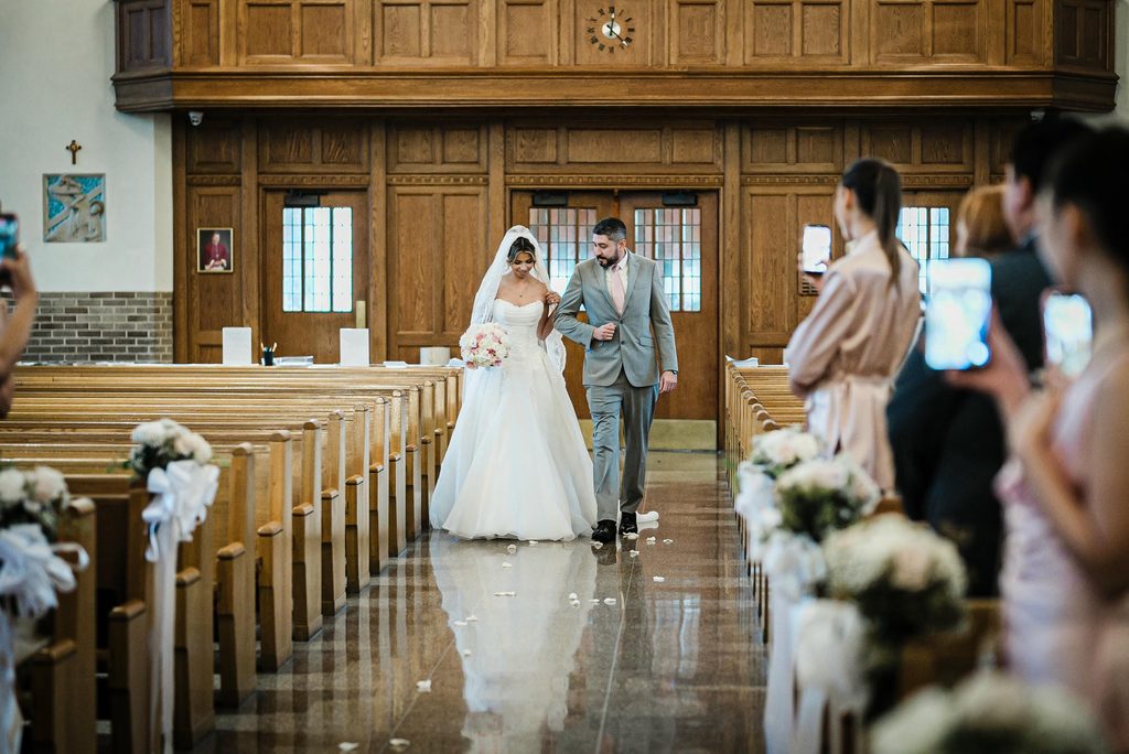 Bride walking down the aisle during a wedding at St. Gregory the Great Church