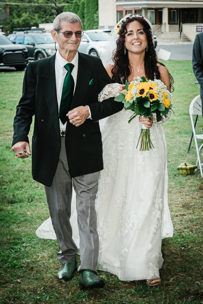 Bride walking down the aisle with an escort at an outdoor Collingswood NJ wedding